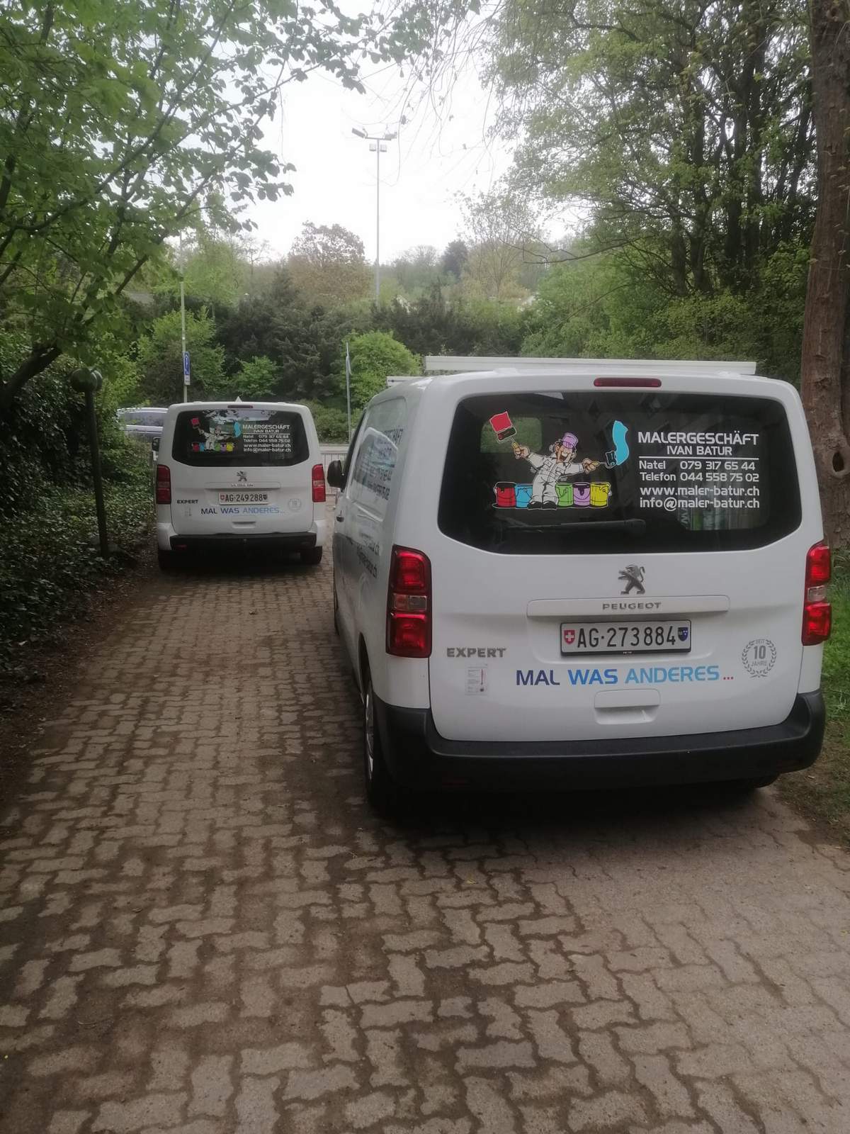 Zwei Firmenfahrzeuge von Maler Batur mit dem ursprünglichen Firmenlogo.